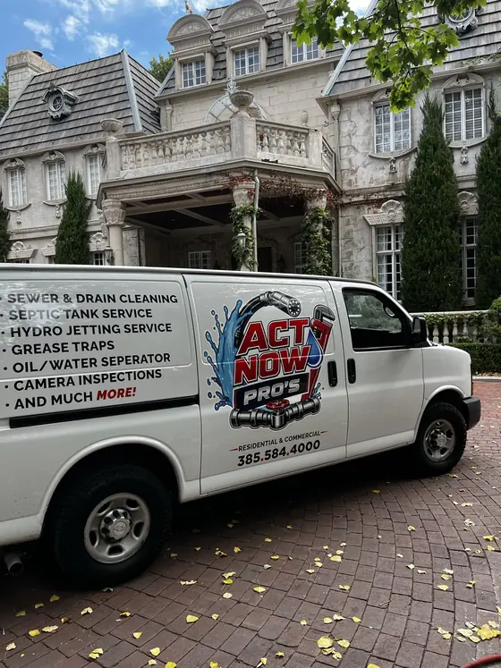 Act Now Pros sewer and drain service van outside a property