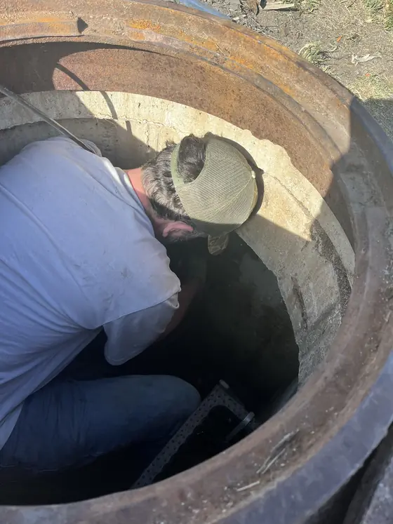 Act Now Pros technician working inside a commercial lift station chamber