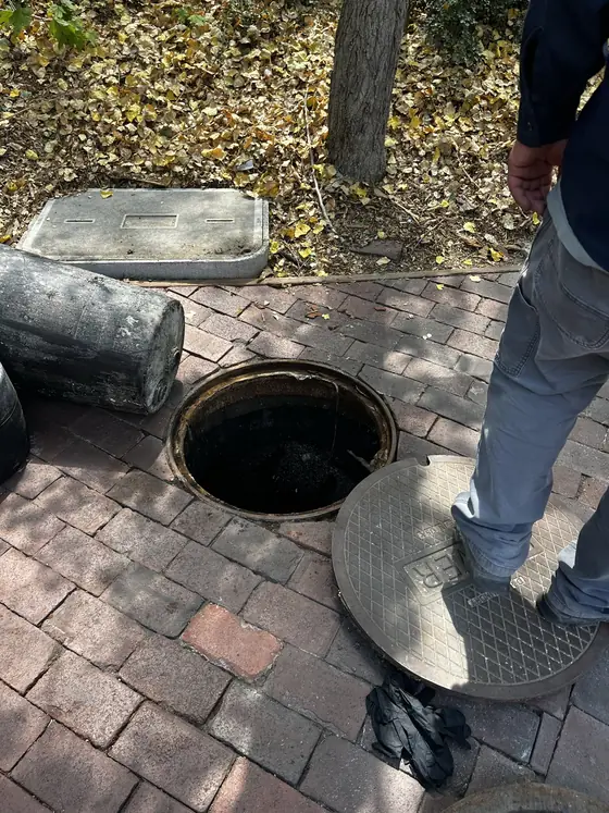 Technician working inside a circular service chamber with a ladder