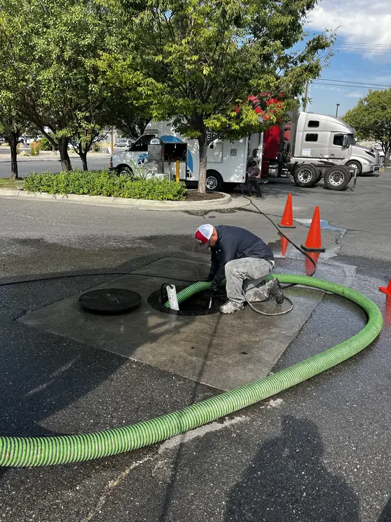 Pumping hose and safety cones around an open service access point