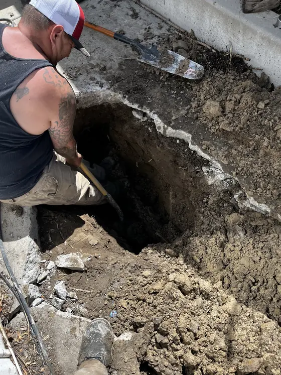 Technician working beside an outdoor excavation