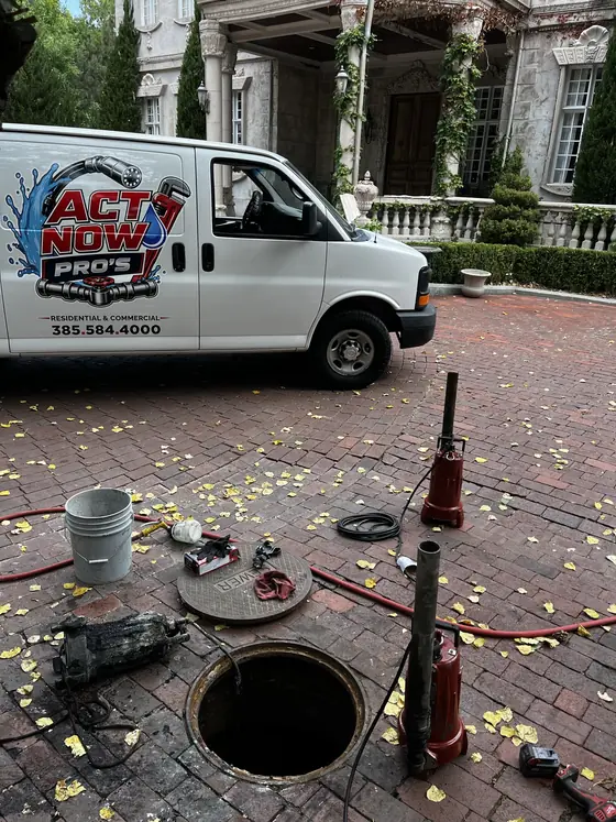 Act Now Pros technician beside an open outdoor service access