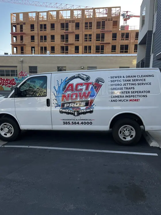 Act Now Pros technician beside an open outdoor service access