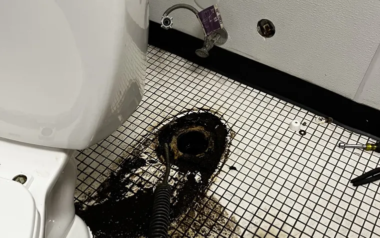 Main line being snaked at an open floor flange